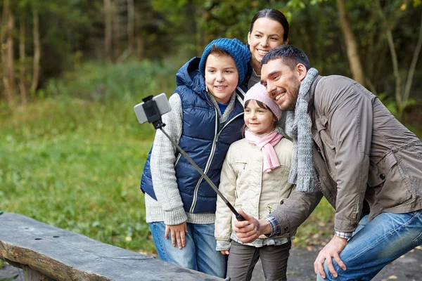 Família feliz com vara selfie smartphone no acampamento — Fotografia de Stock