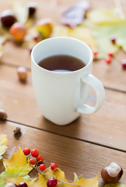Close up de xícara de chá na mesa com folhas de outono — Fotografia de Stock