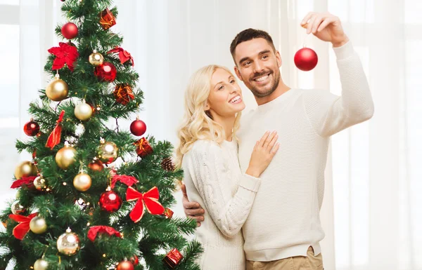 Mutlu çift evde Noel ağacı süslüyorlar. — Stok fotoğraf