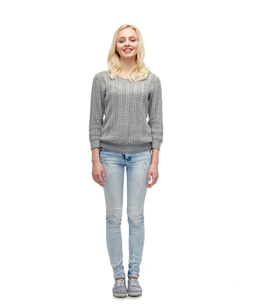 Mujer joven sonriente en jersey gris y jeans — Foto de Stock
