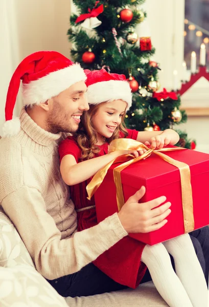 Улыбающиеся отец и дочь открывают подарочную коробку — стоковое фото