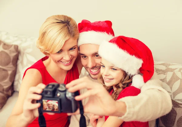 微笑家庭在圣诞老人的助手帽子拍照 — 图库照片