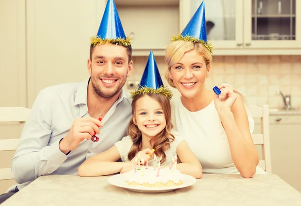 Sonriente familia en sombreros azules soplando cuernos favor —  Fotos de Stock