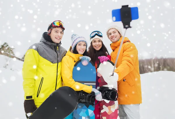 Happy přátelé se snowboardy a smartphone — Stock fotografie