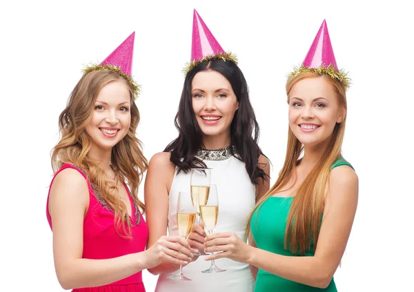 Tre donne in cappelli rosa con bicchieri di champagne — Foto Stock