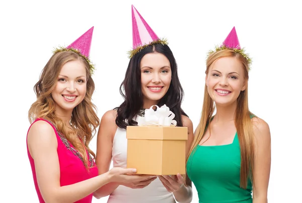 Drei lächelnde Frauen in blauen Hüten mit Geschenkbox — Stockfoto