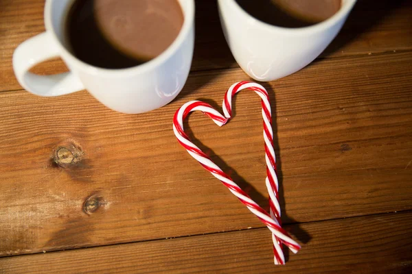 Bastones y copas de caramelo de Navidad en la mesa de madera —  Fotos de Stock