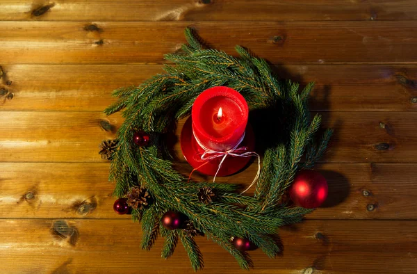 Fir branch wreath with candle on wooden table — Stock Photo, Image