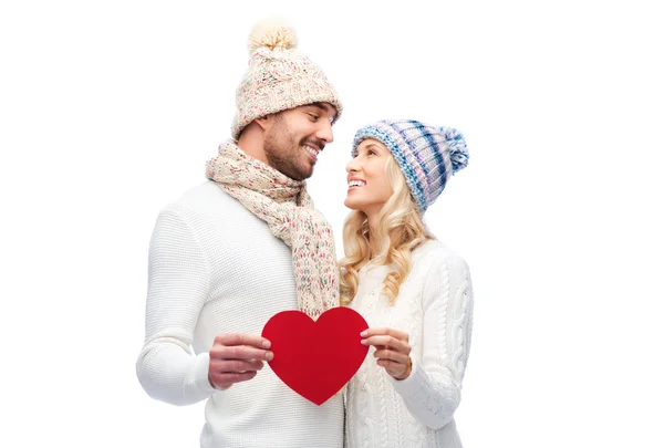 Sonriente pareja en invierno ropa con corazón rojo —  Fotos de Stock