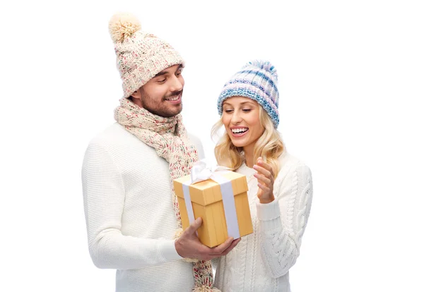 Casal sorridente em roupas de inverno com caixa de presente — Fotografia de Stock