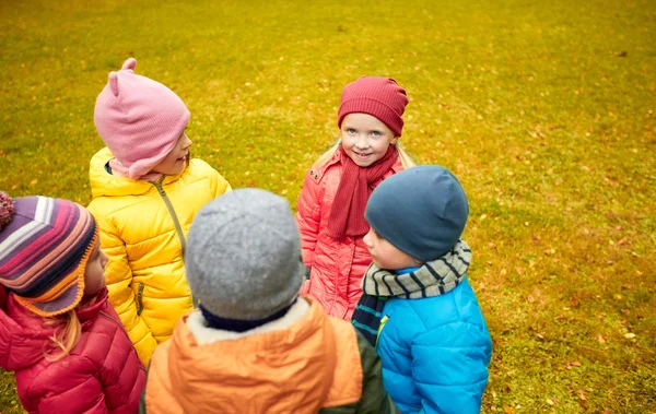 Happy children standing in circle at autumn park — Stock Photo, Image