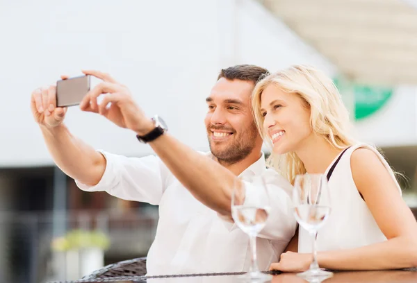 Lyckliga paret tar selfie med smartphone på café — Stockfoto