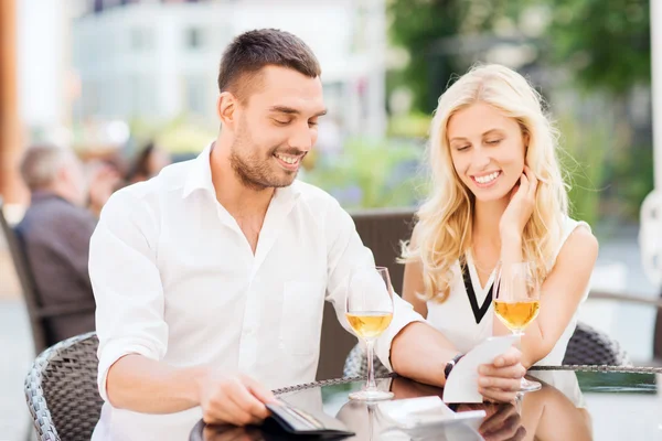 Couple heureux avec portefeuille et facture au restaurant — Photo