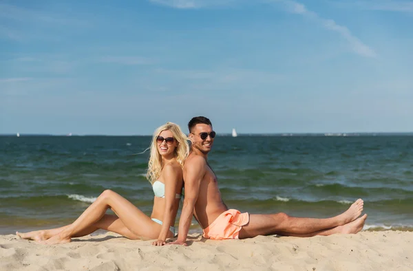 Felice coppia in costume da bagno seduto sulla spiaggia estiva — Foto Stock