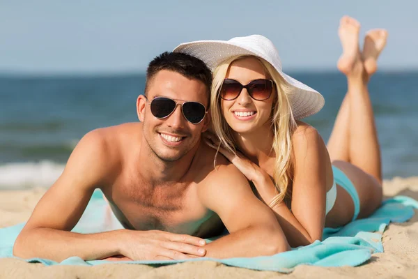 Счастливая пара в купальниках, лежащая на пляже — стоковое фото