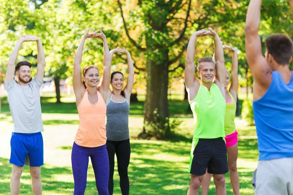 Grupo de amigos o deportistas que hacen ejercicio al aire libre — Foto de Stock