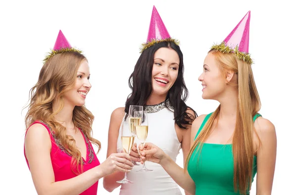 Three women in pink hats with champagne glasses — Stock Photo, Image