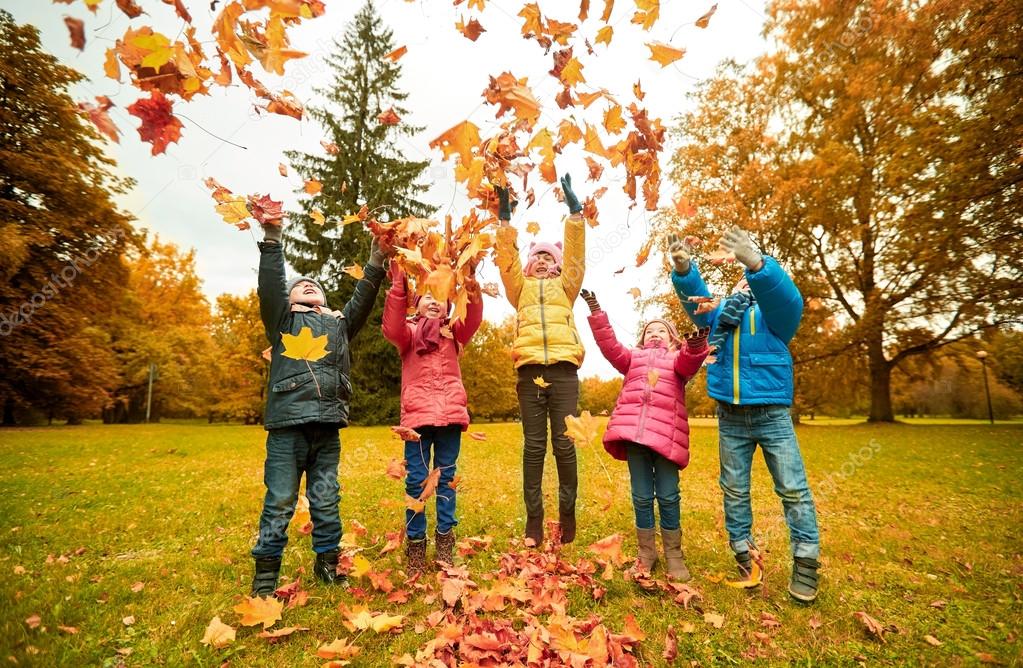 Happy children playing with autumn leaves in park — Stock Photo © Syda ...