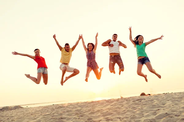 Uśmiechający się przyjaciółmi, taniec i skoki na plaży — Zdjęcie stockowe