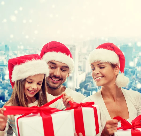 Família feliz em santa helper chapéus com caixas de presente — Fotografia de Stock