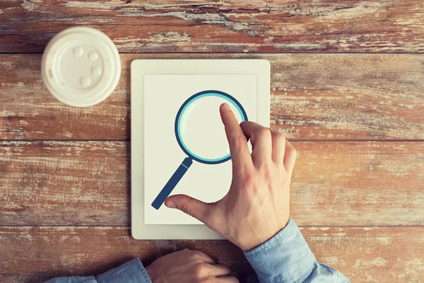 Close up of male hands with magnifier on tablet pc — Stock Photo, Image