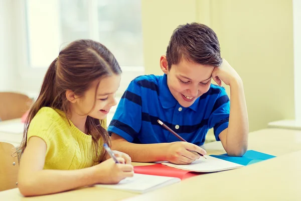 Group of school kids writing test in classroom — Stock Photo, Image