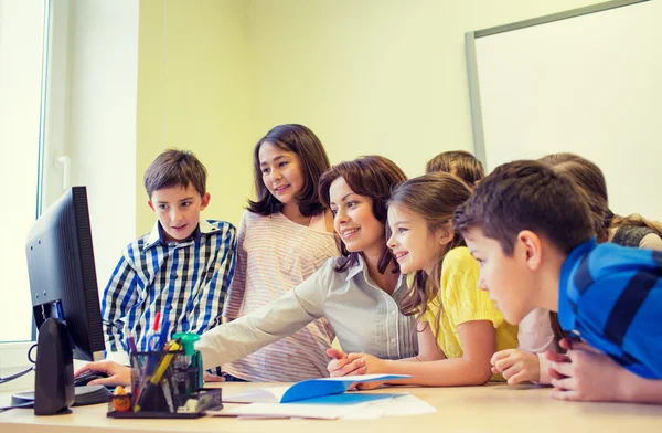 Group of kids with teacher and computer at school — Stock Photo, Image