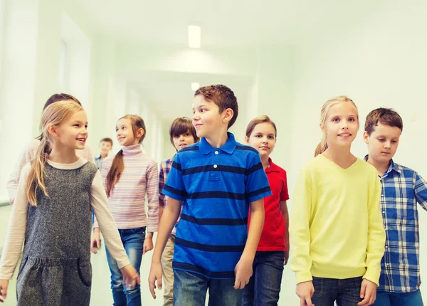 Grupo de niños sonrientes de la escuela caminando en el pasillo —  Fotos de Stock
