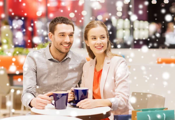 Happy couple with shopping bags drinking coffee — Stock Photo, Image