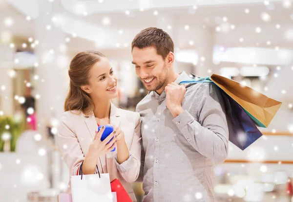 Coppia con smartphone e shopping bag nel centro commerciale — Foto Stock