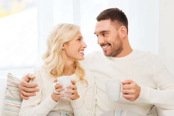 Feliz pareja con tazas de té en casa — Foto de Stock