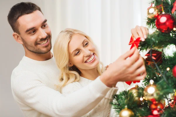 Happy couple decorating christmas tree at home — Stock Photo, Image