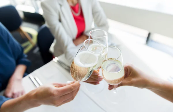 Close up of women clinking champagne at restaurant — ストック写真
