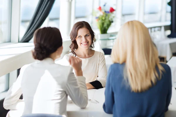 Happy women meeting and talking at restaurant — Stock Photo, Image