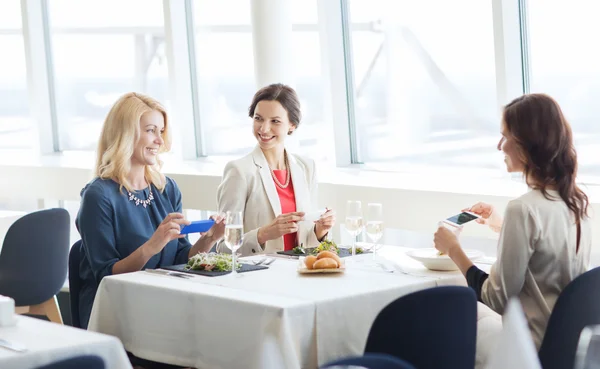 Vrouwen met smartphones foto van voedsel — Stockfoto