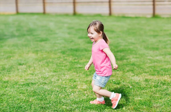 Menina feliz correndo no campo de verão verde — Fotografia de Stock