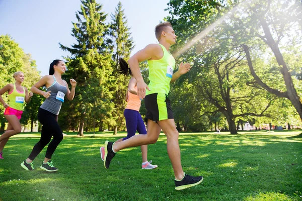 Happ junge Sportler rasen mit Abzeichen-Nummern — Stockfoto