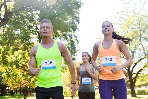 Feliz joven deportistas carreras ingenio insignia números — Foto de Stock