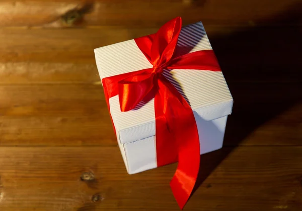 Fechar a caixa de presente de Natal no chão de madeira — Fotografia de Stock