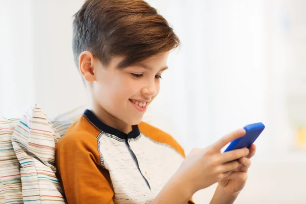 Boy with smartphone texting or playing at home — Stock Photo, Image