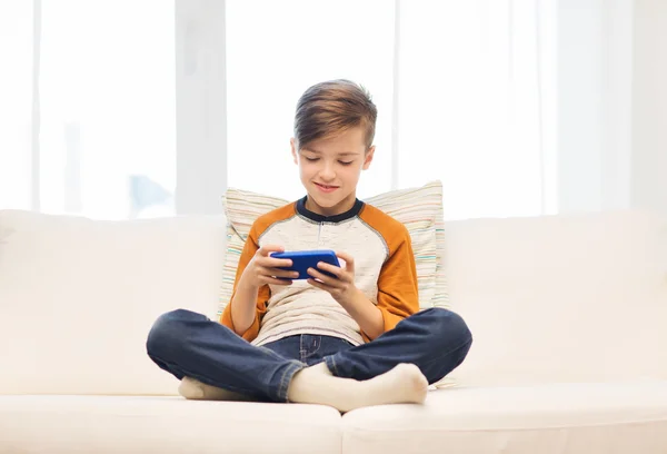 Niño con mensajes de texto de teléfonos inteligentes o jugando en casa —  Fotos de Stock