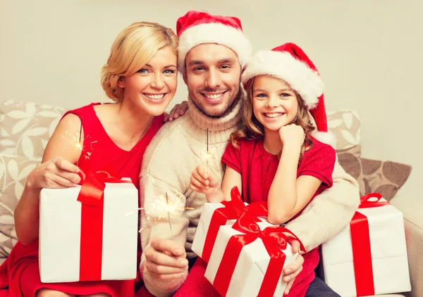 Sorrindo família segurando caixas de presente e brilhos — Fotografia de Stock