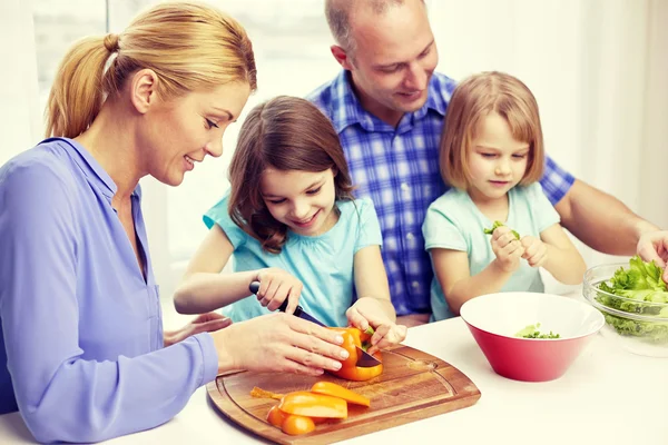Счастливая семья с двумя детьми готовит дома — стоковое фото