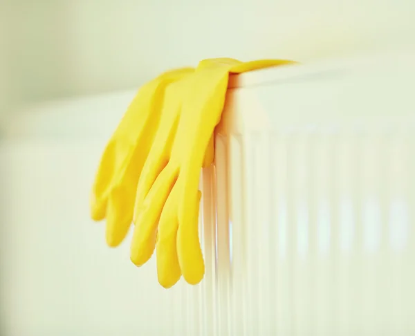 Primer plano de guantes de goma colgando en el calentador —  Fotos de Stock