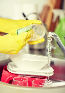 close up of woman hands washing dishes in kitchen clipart