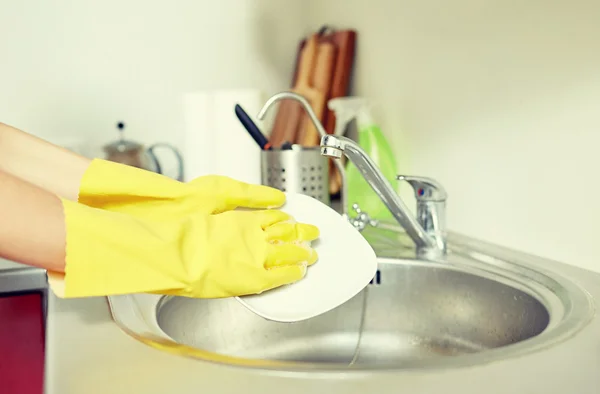 Närbild av kvinna händer tvätta rätter i köket — Stockfoto