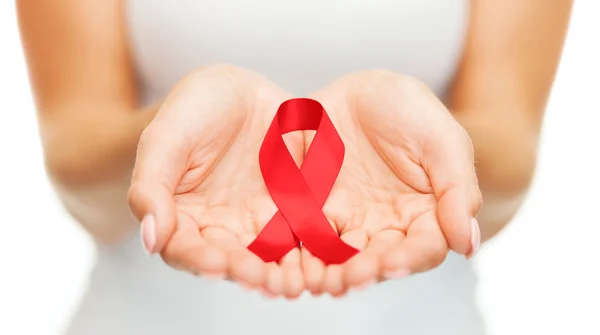 Hands holding red AIDS awareness ribbon — Stock Photo, Image