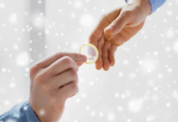 Close up of male gay couple hands giving condom — Stock Photo, Image