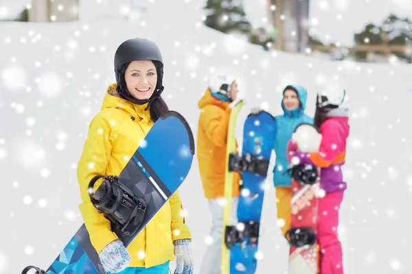 Glückliche Freunde in Helmen mit Snowboards — Stockfoto