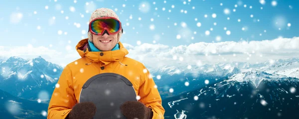 Happy young man in ski goggles over mountains — Stock Photo, Image